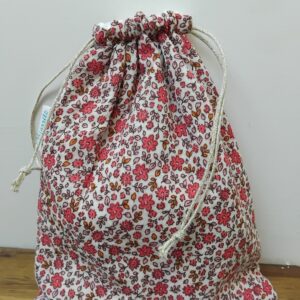 Pochette maillot imperméable en gaze de coton motifs fleuris rose.