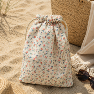 Sac à maillot imperméable en gaze de coton motifs fleuris beiges.