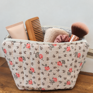 Jolie trousse imperméable en coton matelassé motifs fleuris orangés..